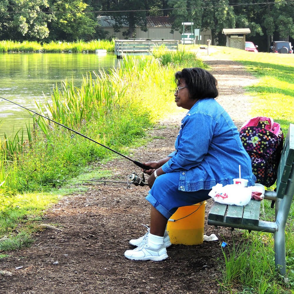 Woman sitting on a bench fishing