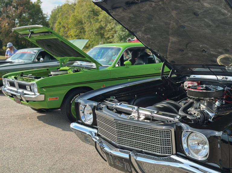old fashioned cars with their hoods up to show off their engines
