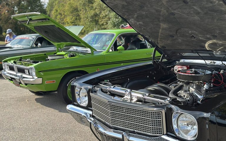 old fashioned cars with their hoods up to show off their engines